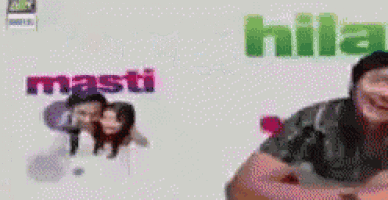 a man is smiling in front of a screen that says hila