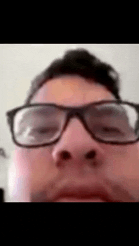 a close up of a man 's face with glasses on
