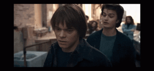 two young men are standing next to each other in a crowd .