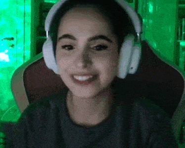 a young girl wearing headphones is smiling while sitting in a chair .