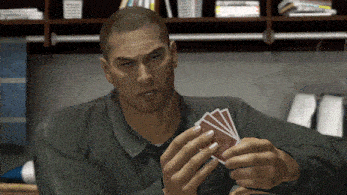 a man in a green shirt is holding four playing cards