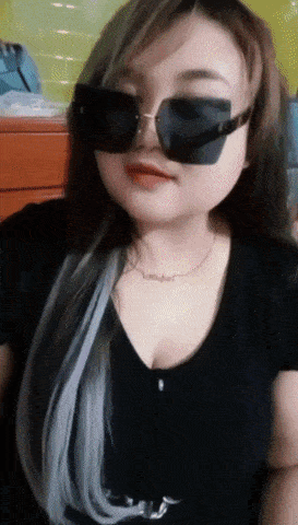a woman wearing sunglasses and a necklace with the word mother