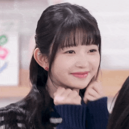 a close up of a young girl making a funny face with her hands .