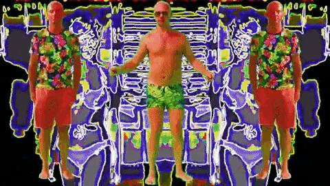a man without a shirt is standing in front of a rainbow colored background .