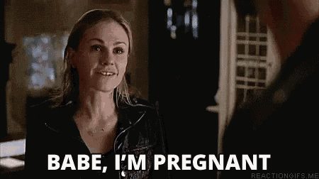 a woman is talking to a man in a dark room and says `` babe , i 'm pregnant '' .