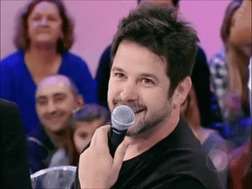 a man with a beard is holding a microphone in his mouth