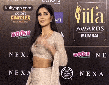 a woman is standing in front of a wall with a sign that says iifa awards .