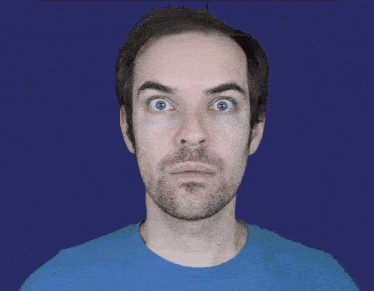 a man wearing glasses and a blue shirt is adjusting his glasses