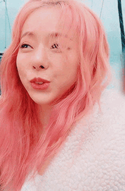 a close up of a woman with pink hair wearing a white jacket