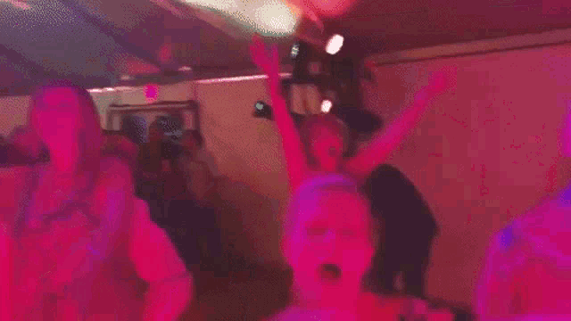 a woman is singing into a microphone while dancing with a man in a club .