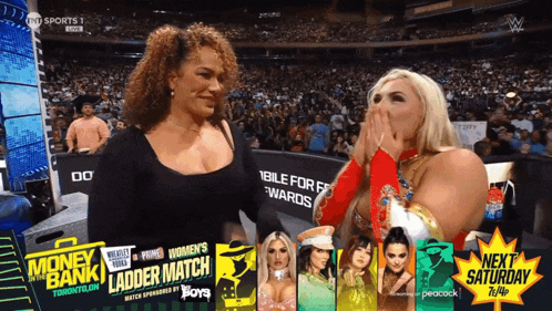 two women standing next to each other in front of a crowd that is watching a ladder match