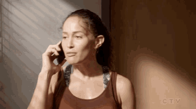 a woman is talking on a cell phone while standing next to a door .