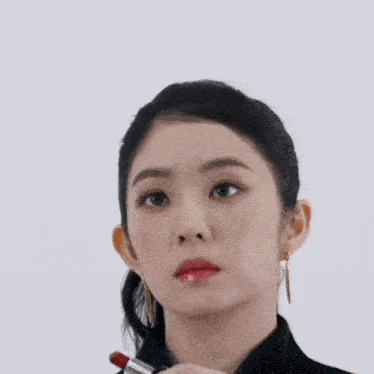 a woman with black nails is holding a red lipstick in her hand