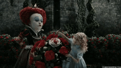 alice and the queen of hearts are standing next to each other