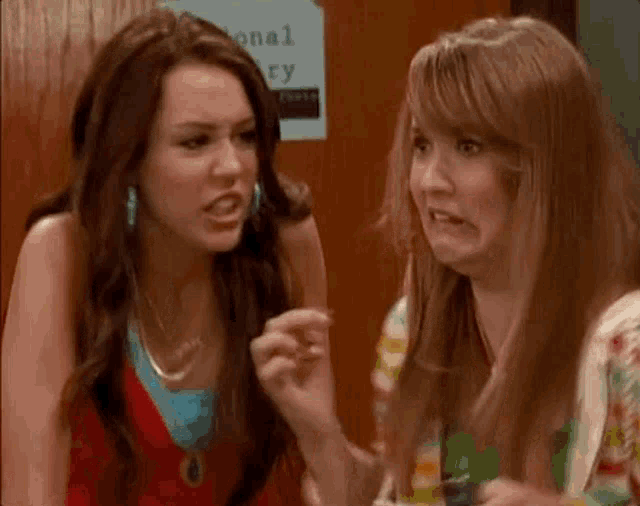 two women are making funny faces while sitting next to each other .