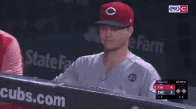 a baseball player wearing a red cubs hat