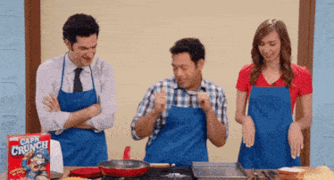 three people wearing blue aprons are cooking with a box of corn crunch