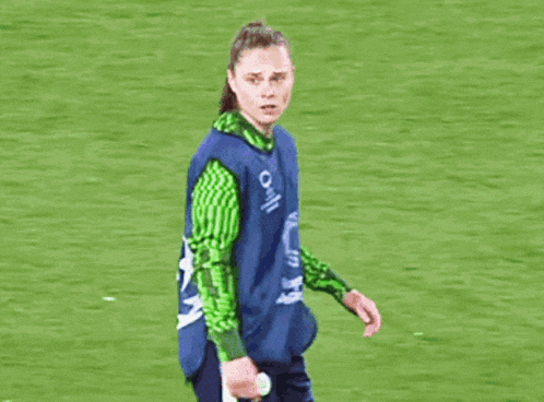 a female soccer player wearing a blue vest that says o on it