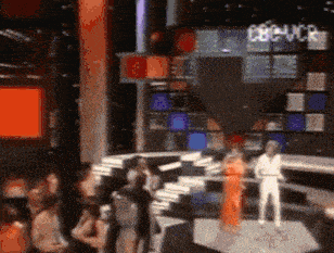 a blurry picture of people on a stage with a sign that says cbvcr in the background