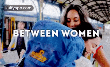 a woman is carrying another woman 's backpack and the words between women are on the screen .