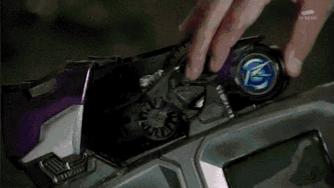 a close up of a person 's hand holding a purple object with a green light behind them