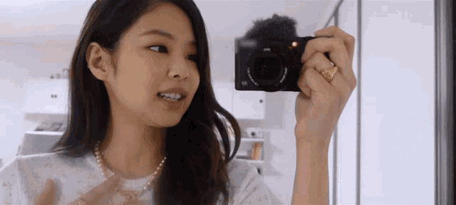 a woman is taking a picture of herself in a mirror with a sony camera