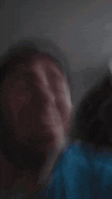 a blurry picture of a man 's face in a blue shirt .