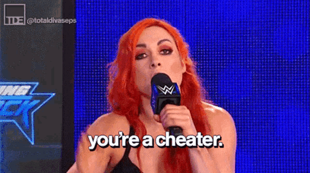 a woman with red hair is holding a microphone and says `` you 're a cheater . ''