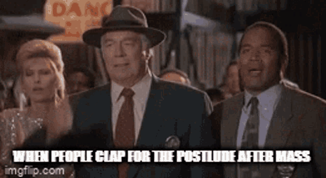 a group of men in suits and ties are standing next to each other in a crowd .