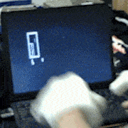 a person is cleaning a laptop with a glove