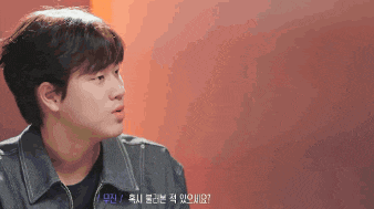 a man in a denim jacket is talking to someone in a foreign language