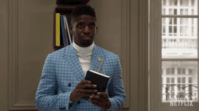 a man in a blue suit is holding a book and a key
