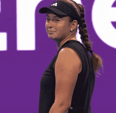 a woman wearing a black tank top and a black hat with the word adidas on it