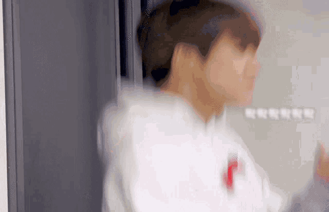 a blurry picture of a man wearing a white hoodie with a red heart on it .