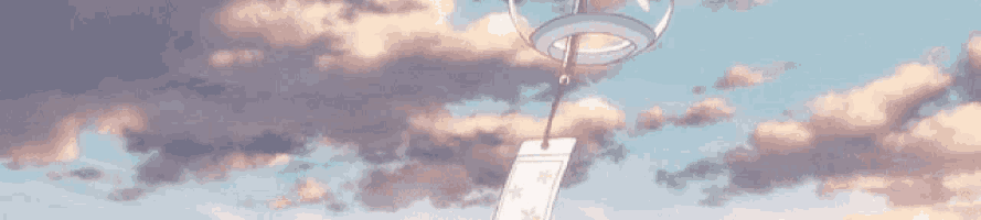 a wind chime hanging from a string in the sky .
