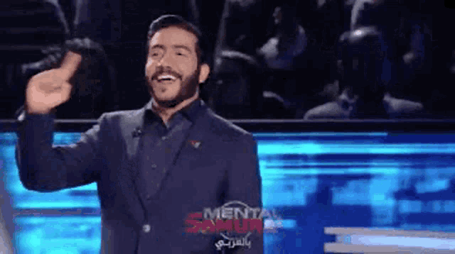 a man in a suit is giving a thumbs up in front of a crowd with the words mental samuel in the background