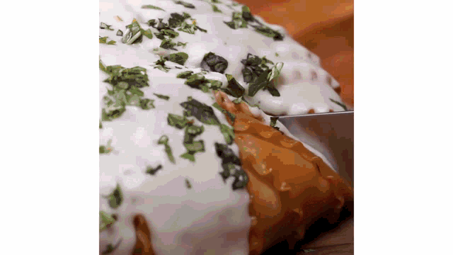a person is cutting a piece of food with a knife on a table .