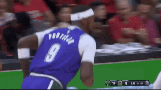 a basketball player wearing a purple jersey with the number 9 on the back
