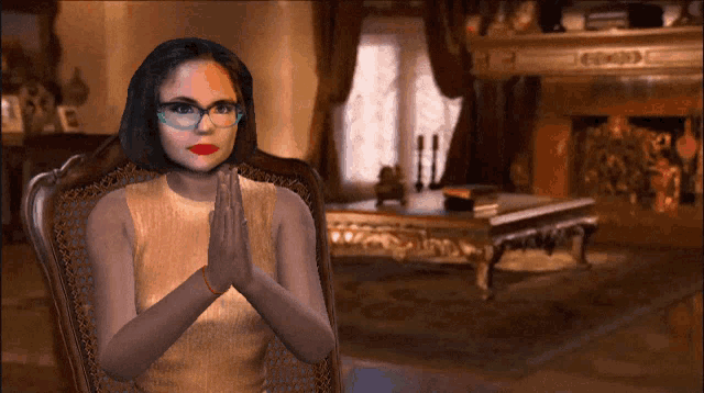 a woman with glasses sits in a chair with her hands folded in front of a fireplace