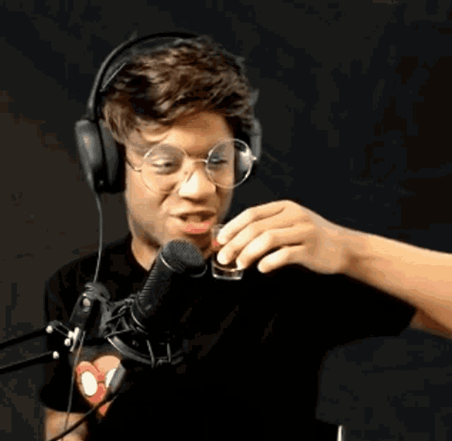 a man wearing headphones and glasses is taking a shot