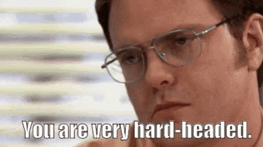 a man wearing glasses is saying `` you are very hard - headed . ''