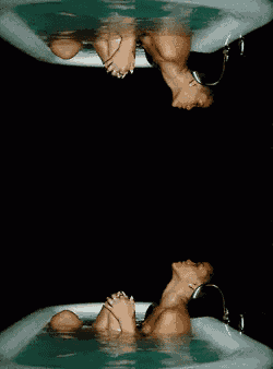 a woman is laying in a bathtub with her head in the water