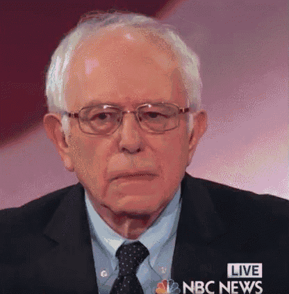 a close up of a man wearing glasses and a suit with the words live nbc news behind him