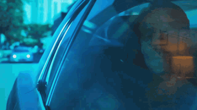 a man is driving a car at night and looking out the window