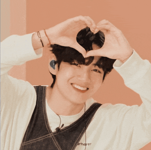 a young man making a heart shape with his hands