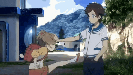 a boy and a girl are standing next to each other and the boy is putting his hand on the girl 's forehead .