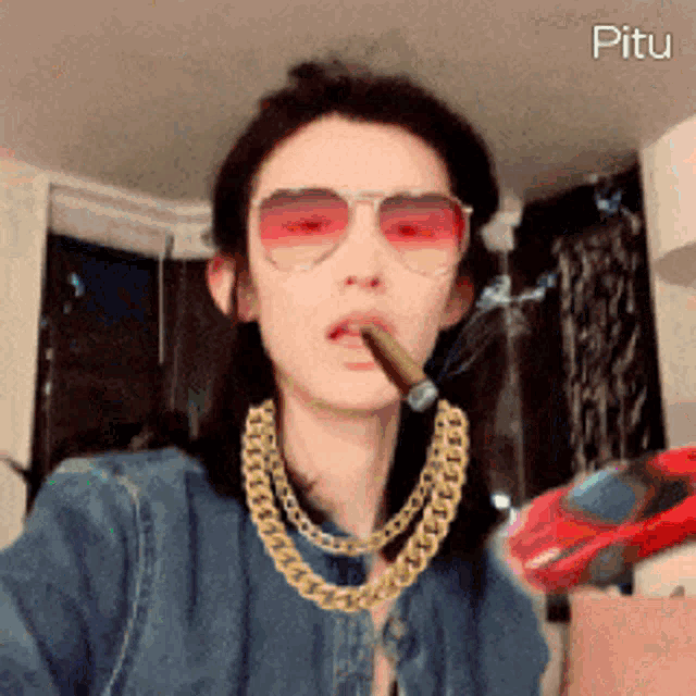 a woman smoking a cigar and wearing sunglasses and a gold chain