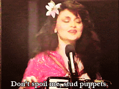 a woman singing into a microphone with the words " do n't spoil me stud puppets " above her