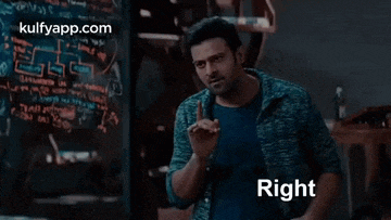 a man in a blue shirt is standing in front of a blackboard with the words `` right '' written on it .