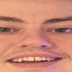a close up of a man 's face with a purple background .